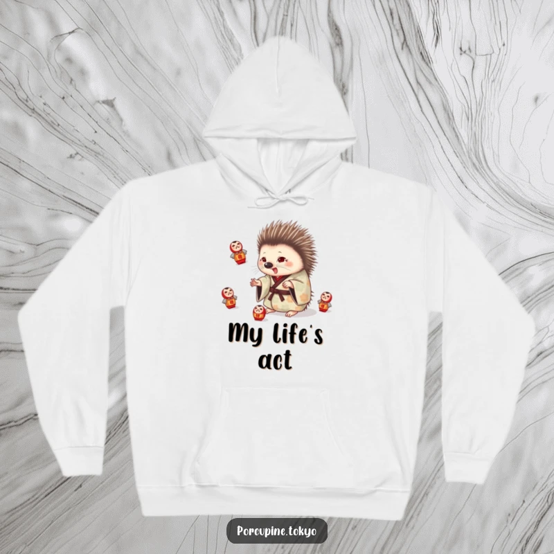Funny hoodie with a porcupine in a patterned kimono playfully juggling small daruma dolls, offering warmth and humor.